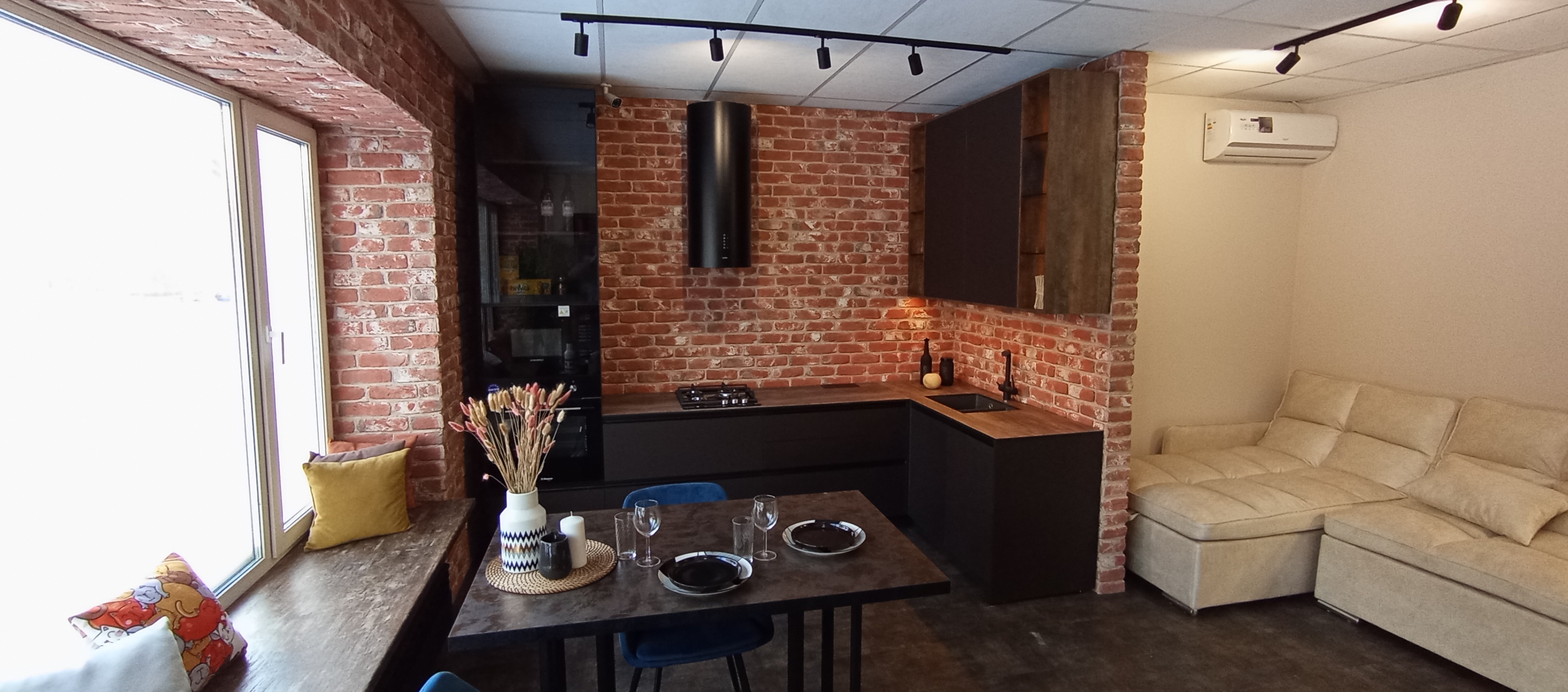 Кухня совмещенная с гостиной: обеденная зона у большого окна - дизайн корпусной мебели от «Финист Терра» фото